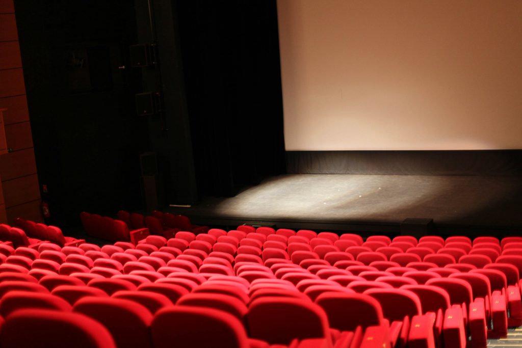 imaginea reprezintă o sală de teatru cu scaune roșii